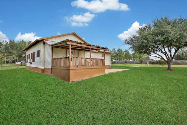 rear view of house with a wooden deck and a yard