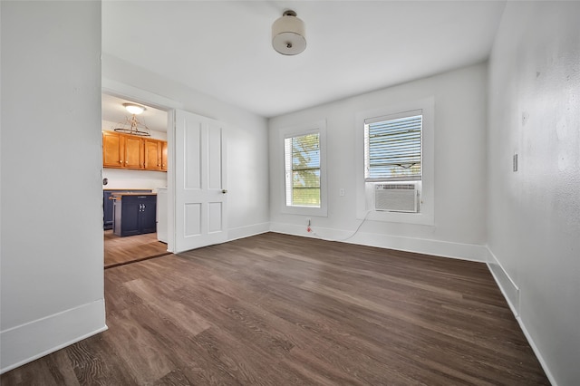 unfurnished room featuring cooling unit and dark hardwood / wood-style flooring