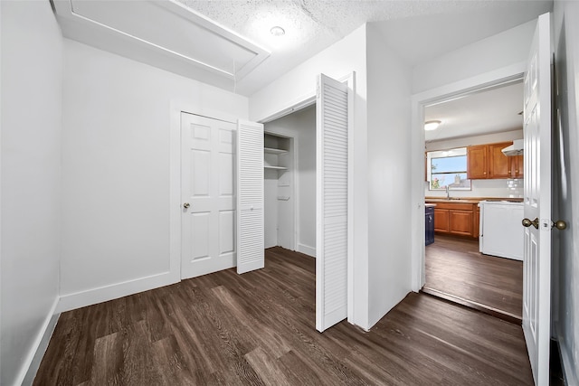 interior space featuring a textured ceiling, dark wood-type flooring, and sink