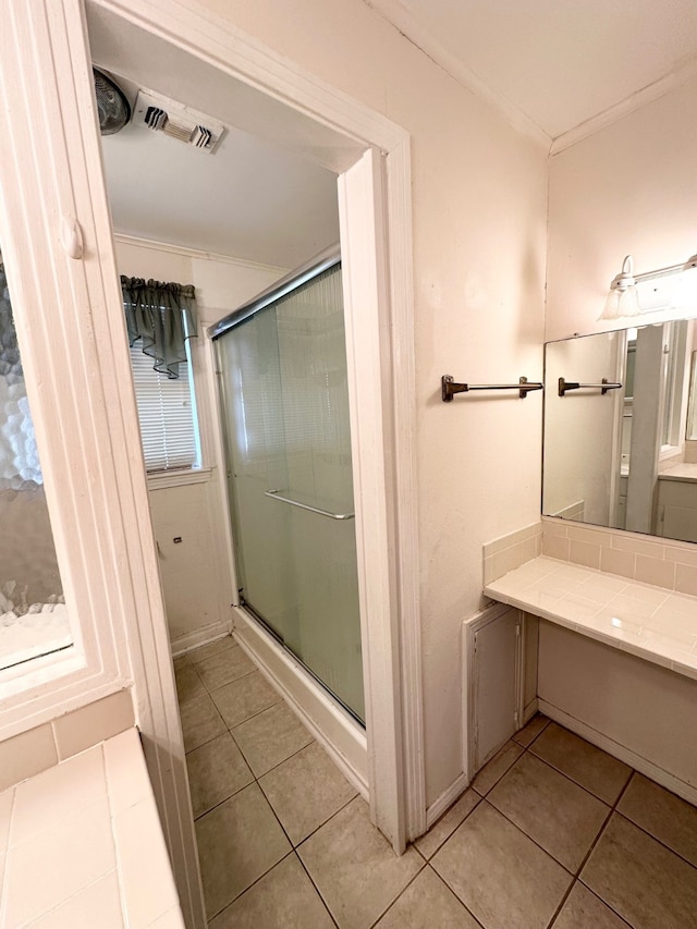 bathroom featuring ornamental molding, vanity, walk in shower, and tile patterned floors