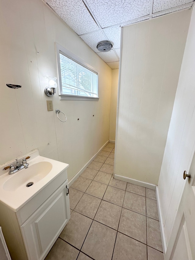 bathroom featuring a drop ceiling, tile patterned floors, and vanity