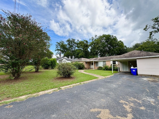 ranch-style house featuring a front yard and a carport