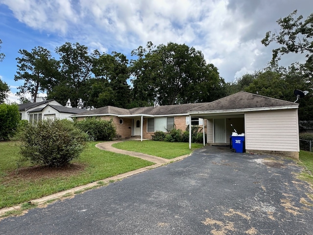 ranch-style house featuring a front lawn and a carport