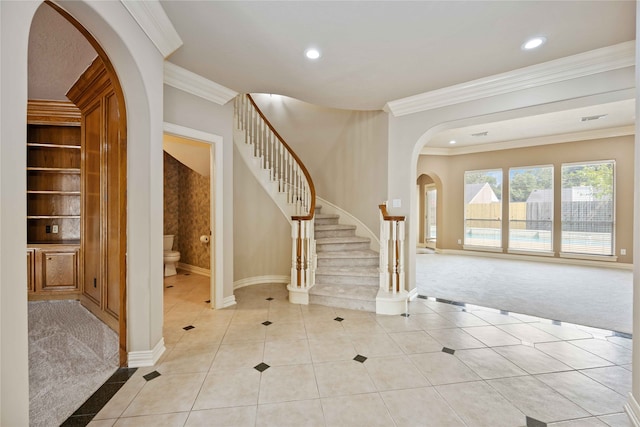 carpeted entryway featuring crown molding