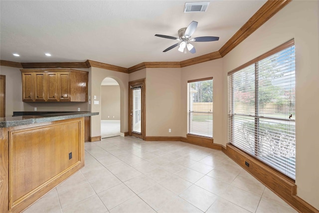 kitchen with ceiling fan, crown molding, and light tile patterned flooring