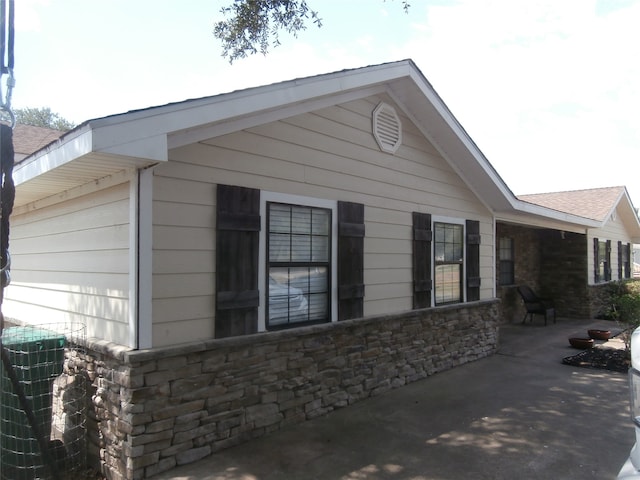 view of side of property with cooling unit and a patio