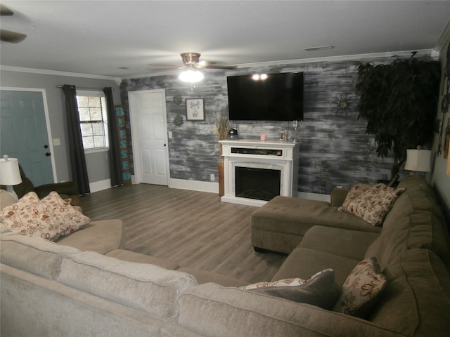 living room with wood-type flooring, crown molding, and ceiling fan