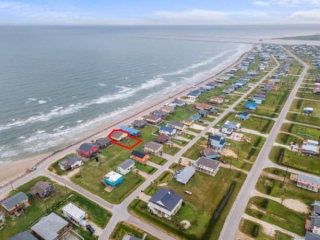 aerial view with a water view and a beach view