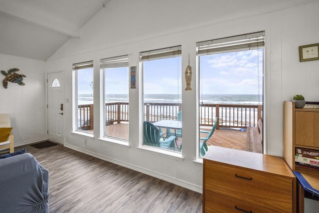 interior space with lofted ceiling with beams, a water view, and a healthy amount of sunlight