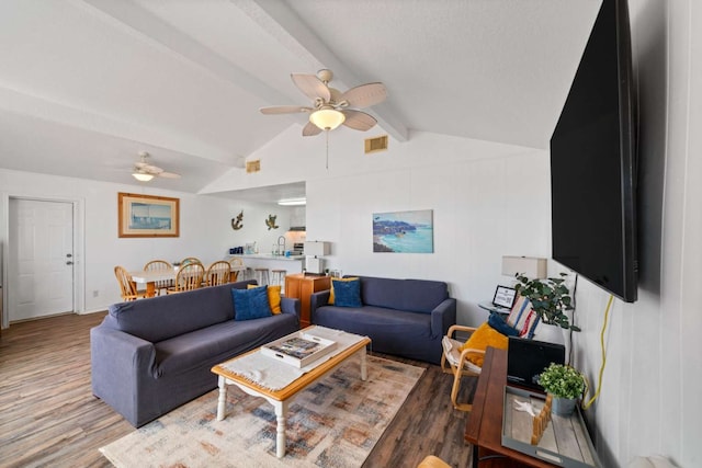 living room featuring lofted ceiling with beams, dark wood-type flooring, and ceiling fan