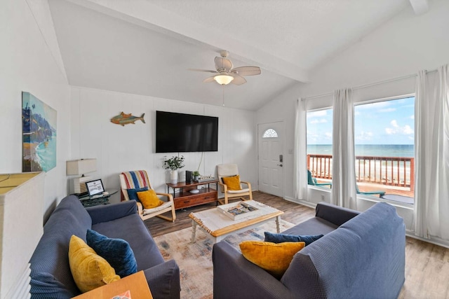 living room featuring vaulted ceiling with beams, light wood-type flooring, and ceiling fan