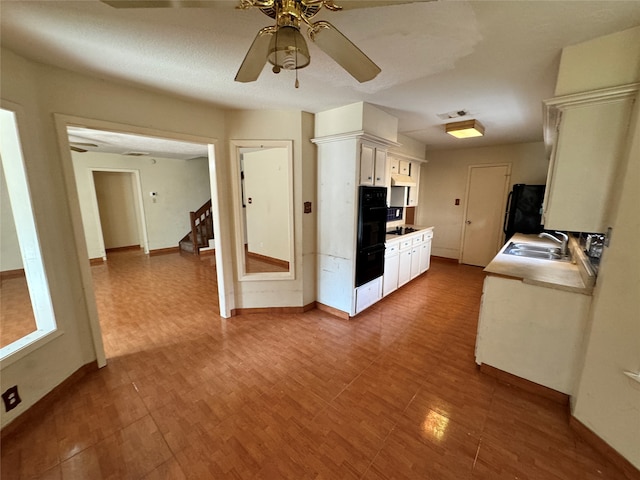 kitchen with ceiling fan, white cabinets, sink, a textured ceiling, and refrigerator