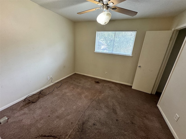 unfurnished bedroom featuring ceiling fan, a textured ceiling, and dark carpet