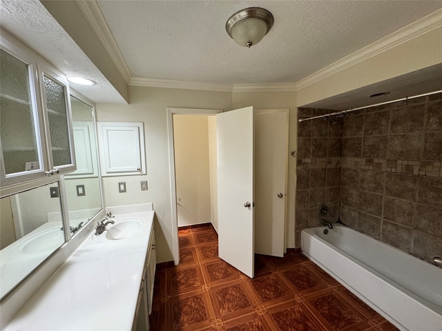 bathroom with ornamental molding, a textured ceiling, tiled shower / bath, and vanity