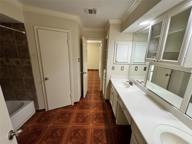 bathroom with vanity, a textured ceiling, crown molding, tile patterned flooring, and a tub