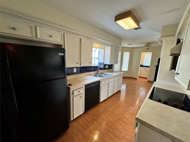 kitchen with ceiling fan, sink, tasteful backsplash, black appliances, and light hardwood / wood-style floors