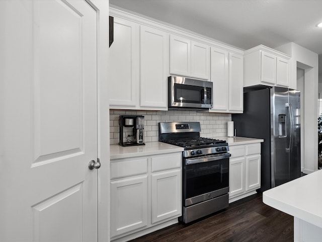 kitchen featuring white cabinets, dark hardwood / wood-style floors, backsplash, and appliances with stainless steel finishes