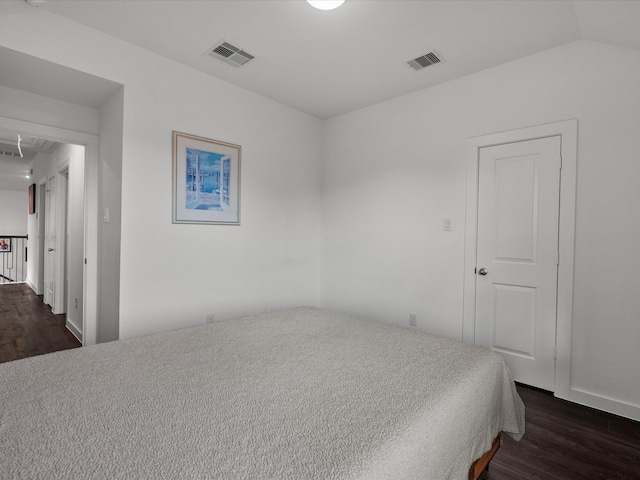 bedroom featuring dark wood-type flooring and vaulted ceiling