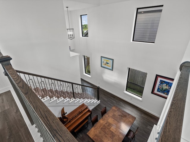 staircase featuring wood-type flooring and a chandelier