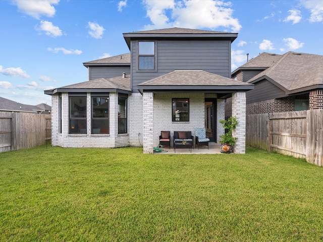 rear view of property featuring a lawn and a patio area