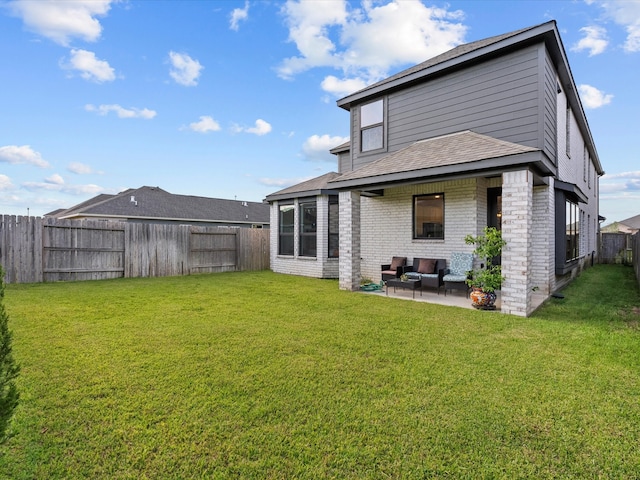 back of property with a lawn and a patio area