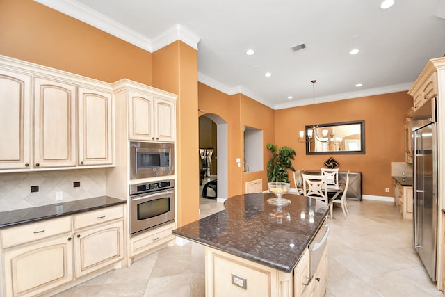 kitchen with backsplash, dark stone counters, pendant lighting, built in appliances, and ornamental molding