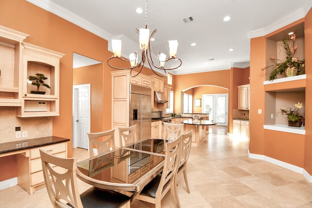 tiled dining area featuring ornamental molding and a chandelier