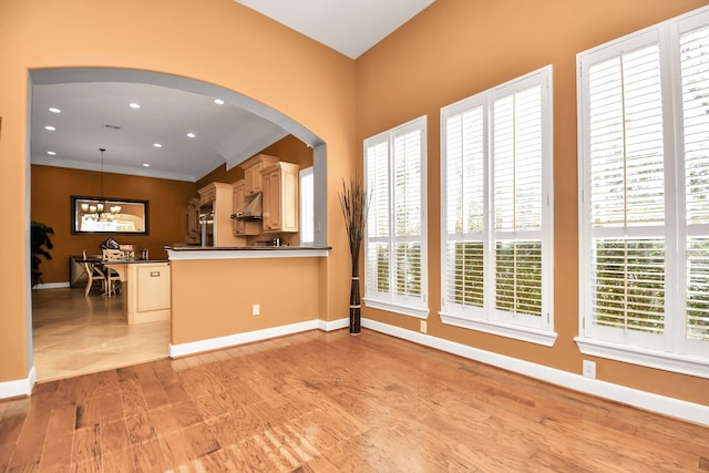 kitchen with light hardwood / wood-style flooring, a chandelier, decorative light fixtures, and a wealth of natural light