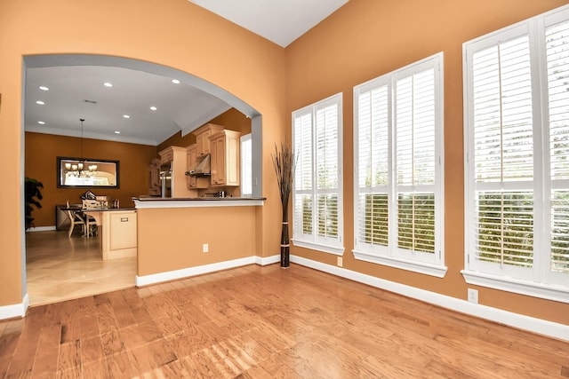 15 Bees Creek Ct, Missouri City, TX 77459 - kitchen with under cabinet range hood, dark countertops, arched walkways, a chandelier, and baseboards