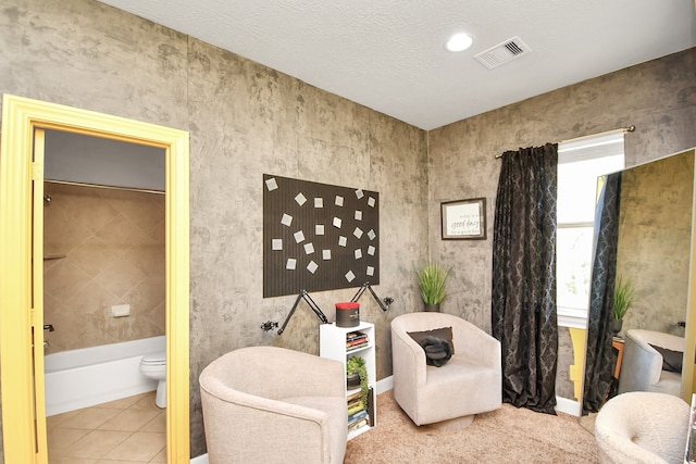 sitting room with a textured ceiling and tile patterned flooring