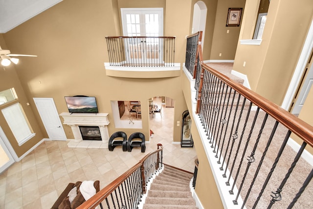 stairway with a tile fireplace and a high ceiling