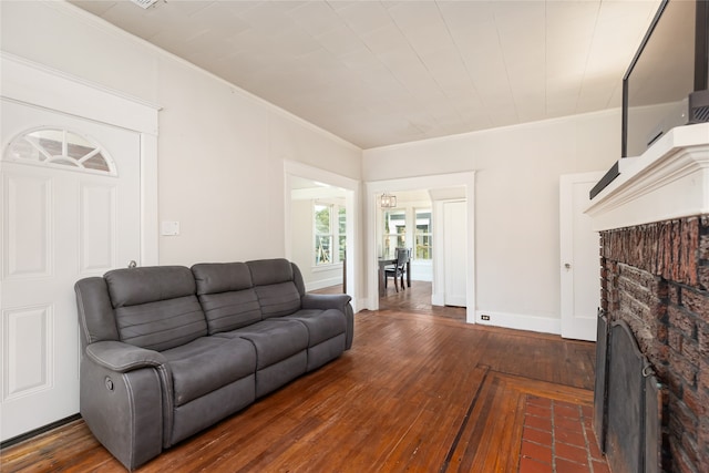 living room with ornamental molding, dark hardwood / wood-style floors, and a fireplace