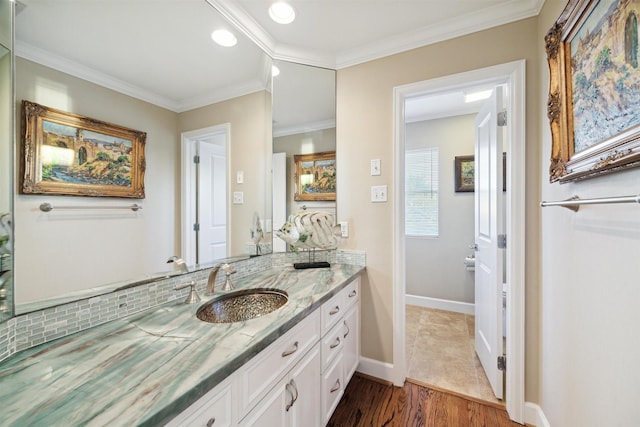 bathroom featuring vanity, wood-type flooring, and ornamental molding