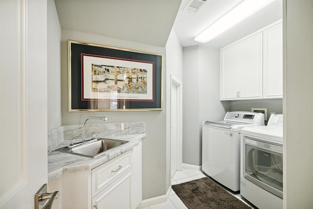 laundry area featuring cabinets, washer and clothes dryer, sink, and light tile patterned floors