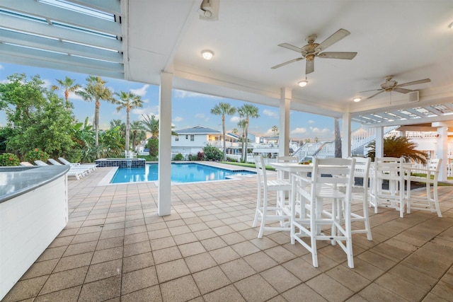 view of swimming pool featuring ceiling fan and a patio