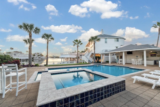 view of swimming pool with a patio area, an outdoor bar, and an in ground hot tub