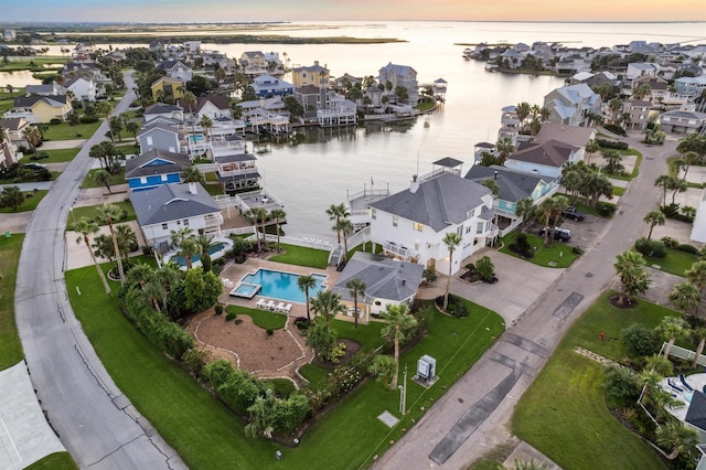 aerial view at dusk featuring a water view