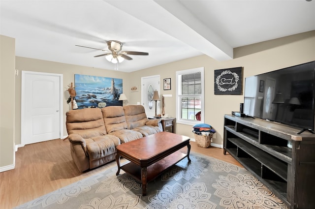 living room featuring light hardwood / wood-style floors, ceiling fan, and beamed ceiling