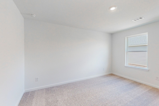 spare room featuring light colored carpet