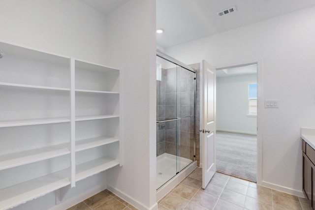 bathroom featuring walk in shower, tile patterned flooring, and vanity