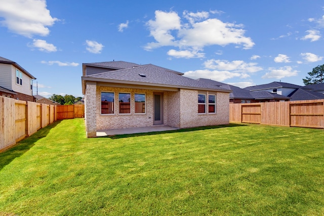 rear view of property with a lawn and a patio area