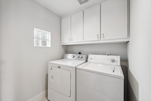 laundry area with cabinets, light tile patterned flooring, and washer and clothes dryer