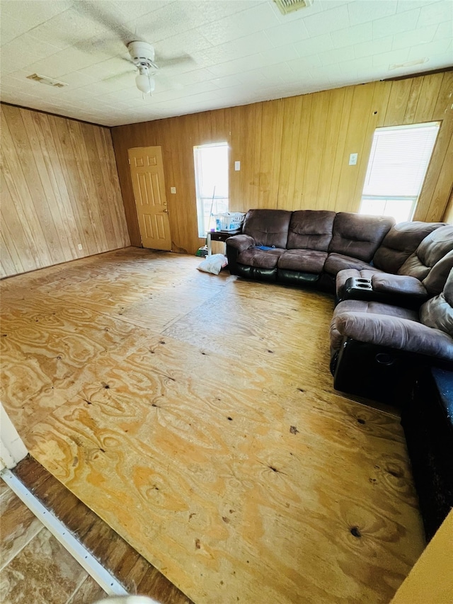 living room with wooden walls and ceiling fan