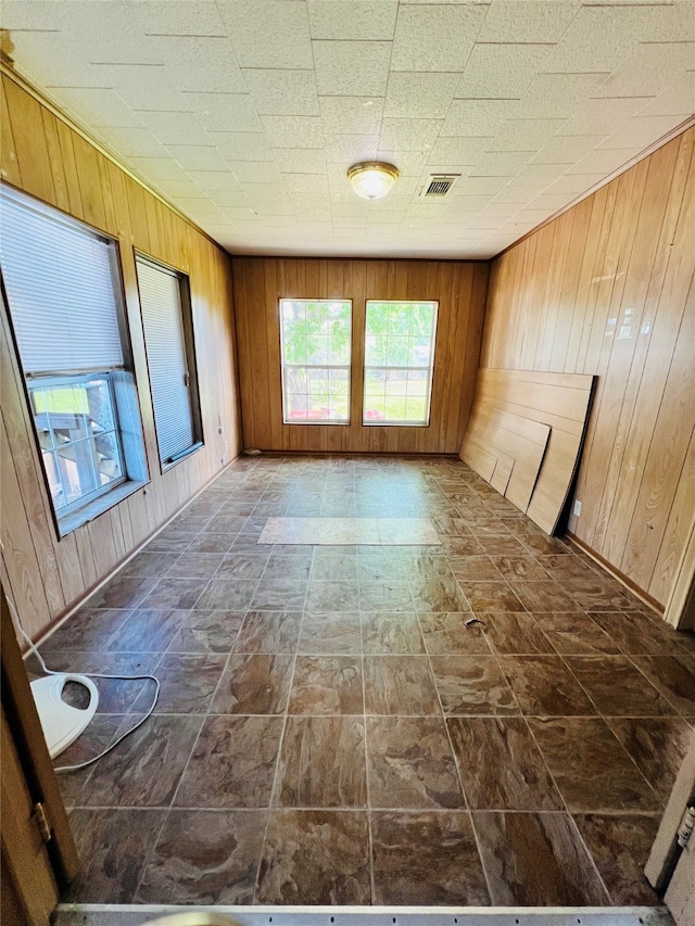 unfurnished room with wood walls