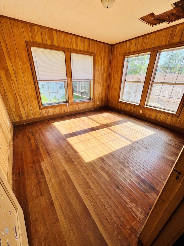 empty room featuring wood walls and light wood-type flooring