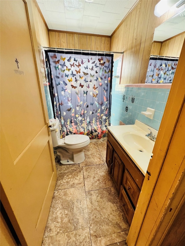 bathroom with toilet, wooden walls, vanity, a shower with shower curtain, and tile walls