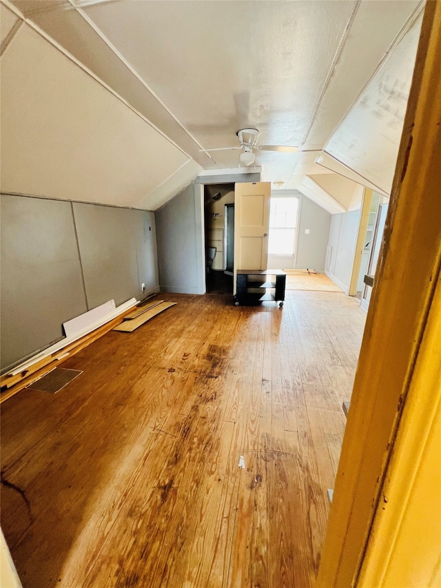 additional living space featuring vaulted ceiling, hardwood / wood-style flooring, and ceiling fan