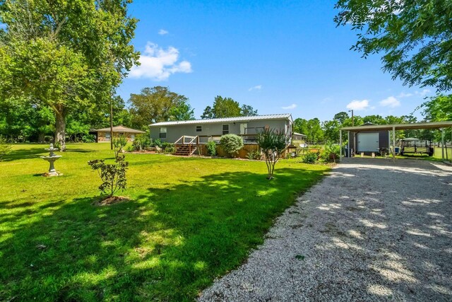 manufactured / mobile home with a carport, a wooden deck, and a front lawn