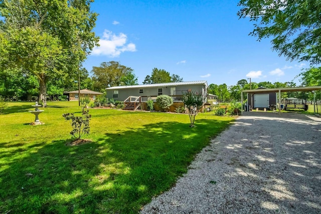 manufactured / mobile home featuring a carport, a garage, and a front lawn