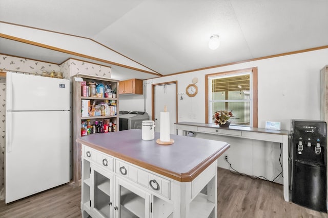 kitchen featuring separate washer and dryer, lofted ceiling, white refrigerator, a center island, and light hardwood / wood-style flooring